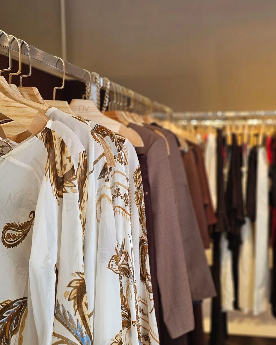 Stylish assortment of clothes hanging on racks in a fashionable boutique featuring elegant patterns.